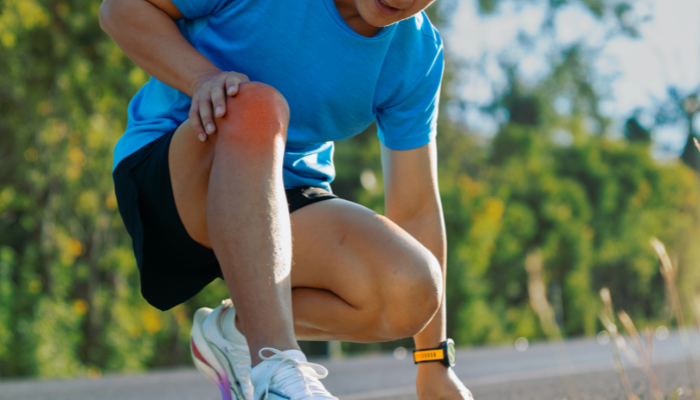 Runner holding knee pain showing need for Pain Bundle by 1906