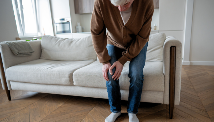 Older adult holding knee showing CBD for arthritis pain relief