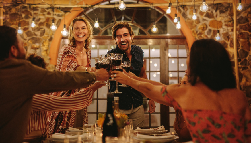Friends toasting drinks at a dinner party