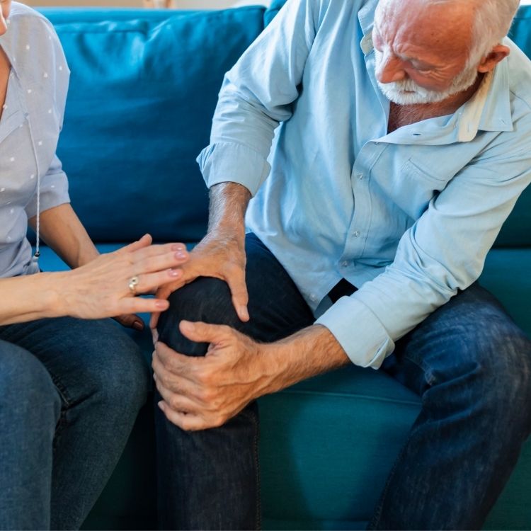 Older adult holding his knee in arthritis pain