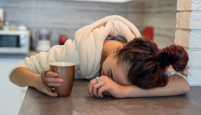 Sleep deprived woman holding coffee showing focus issues in American adults