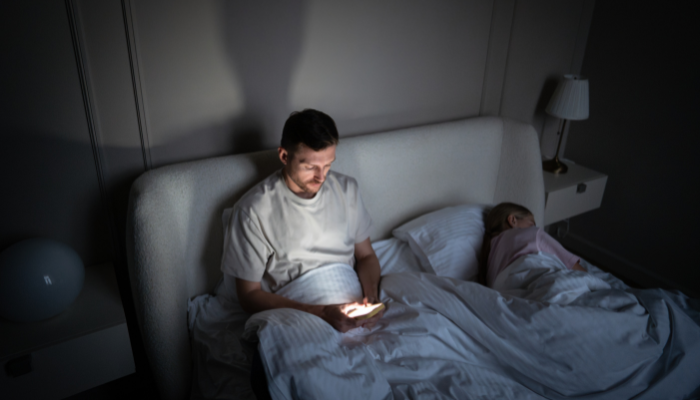 Man using phone at night showing sleep problems and insomnia in American adults